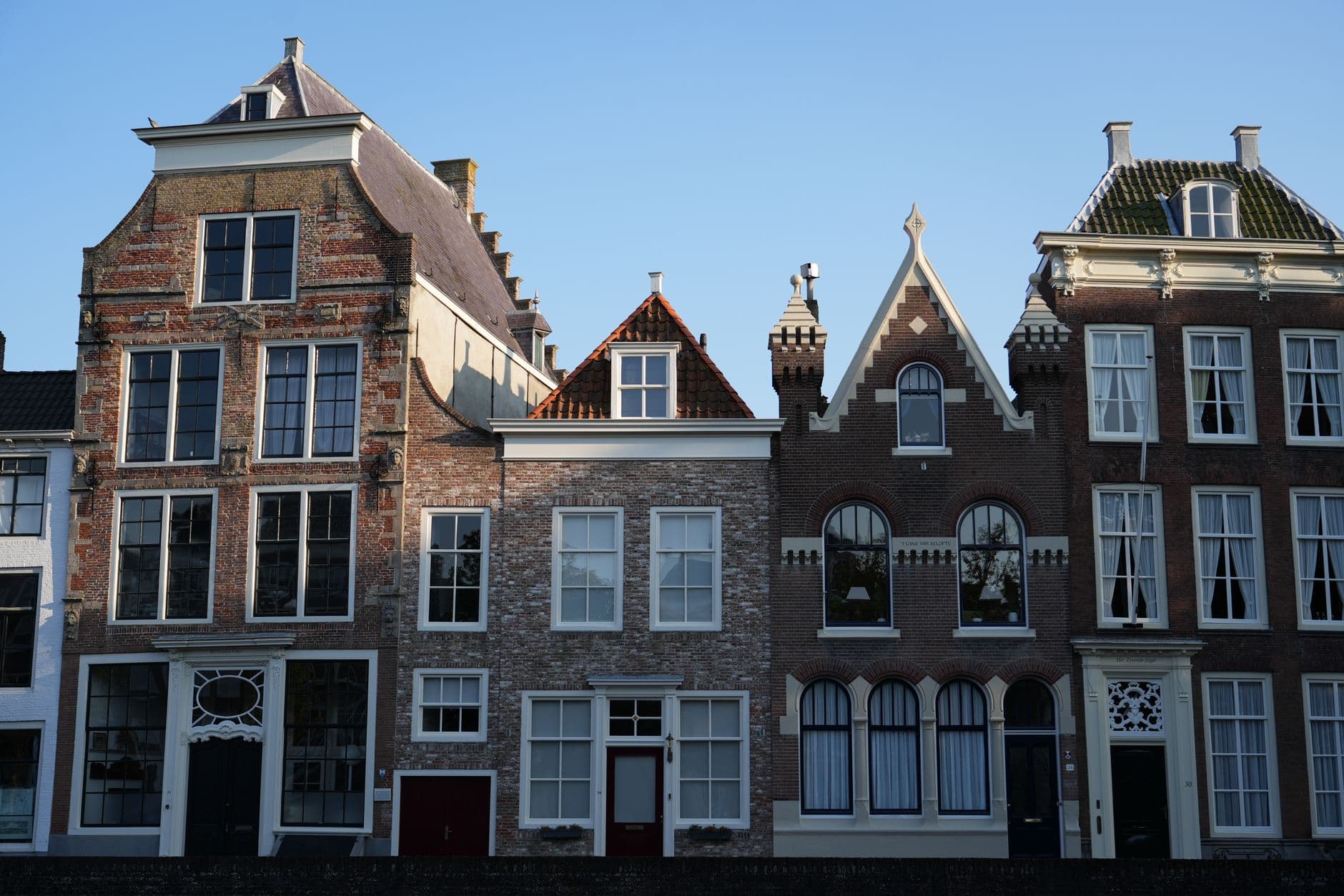 Historische bakstenen gevels van oude herenhuizen in Middelburg onder een blauwe lucht