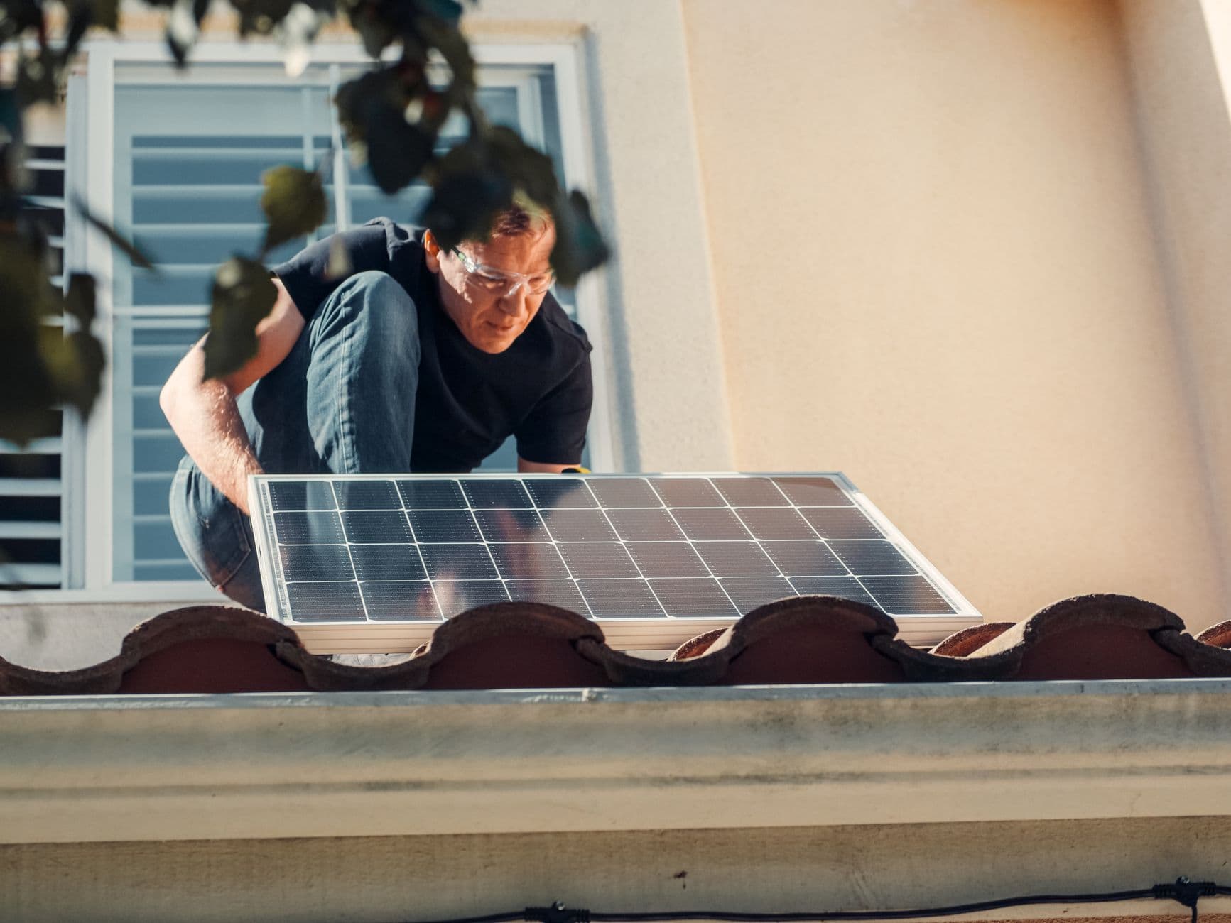 Technicus plaatst een zonnepaneel op het dak van een woning
